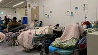 Pasien Covid-19 di tempat tidur di Rumah Sakit Tianjin Nankai di Tianjin (28/12/2022). Kota-kota di seluruh China berjuang melawan lonjakan infeksi, mengakibatkan kekurangan obat-obatan dan bangsal rumah sakit serta krematorium yang meluap setelah Beijing tiba-tiba membongkar kuncian nol-Covid dan rezim pengujian. (AFP/Noel Celis)