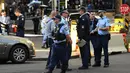Polisi berjaga di tempat kejadian setelah seorang pria menikam seorang wanita dan berusaha menikam orang lain di pusat kota Sydney (13/8/2019). Polisi mengatakan wanita itu dalam kondisi stabil tidak mengalami luka. (AFP Photo/Saeed Khan)
