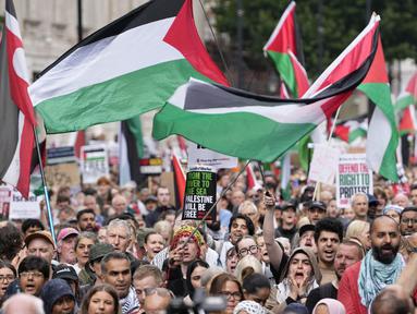 Para pendukung pro-Palestina memegang plakat dan mengibarkan bendera di Downing Street di pusat kota London, Inggris pada 19 Juli 2025. (CARLOS JASSO/AFP)