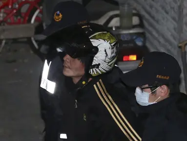 Pelaku pemenggal bocah perempuan (tengah) diamankan polisi ke Pusat Penahanan Taipei, Taiwan, Selasa (29/3). Pria itu memenggal kepala bocah tiga tahun dengan menggunakan pisau daging di hadapan ibu kandung bocah tersebut. (REUTERS/Tony HuangTAIWAN OUT)