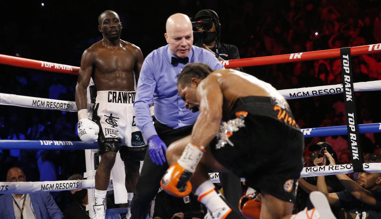 Terence Crawford (kiri) menjatuhkan Shawn Porter pada pertandingan tinju perebutan gelar juara dunia kelas welter WBO di Las Vegas, Amerika Serikat, 20 November 2021. Terence Crawford menang TKO pada ronde 10. (AP Photo/Chase Stevens)