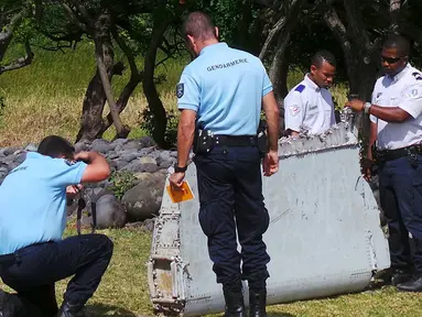 Polisi berdiri dekat potongan mirip badan pesawat di pantai Saint - Andre, Perancis, Rabu  (29/30/2015). Lembaga investigasi Perancis akan berkoordinasi dengan pemerintah Malaysia dan Australia apa itu dari Malaysia Airlines MH370. (REUTERS/Prisca Bigot)