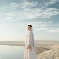 Cantiknya Nagita Slavina di tengah padang pasir menggunakan kaftan dan kerudung putih yang menutupi kepalanya. Gayanya bak princess Arab. [Foto: Instagram/raffinagita1717]