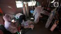 Pasien covid-19 bertelungkup karena kesulitan bernafas saat menjalani perawatan di dalam tenda darurat di RSUD Kota Bekasi, Jumat (25/06/2021). Puluhan pasien covid-19 saat ini dirawat dalam tenda darurat karena keterisian tempat tidur yang penuh akibat lonjakan kasus. (merdeka.com/Arie Basuki)