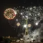 Kembang api menerangi Menara Eiffel selama perayaan Hari Bastille di Paris, Kamis (14/7/2022) malam. Penyerbuan penjara Bastille dipandang sebagai simbol pemberontakan bangsa dan rekonsiliasi seluruh rakyat Prancis. (AP Photo/Lewis Joly)