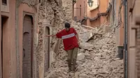 Seorang warga berjalan di antara reruntuhan bangunan setelah gempa berkekuatan 6,8 SR di Marrakesh, Maroko, Sabtu (9/9/2023). (Photo by FADEL SENNA / AFP)