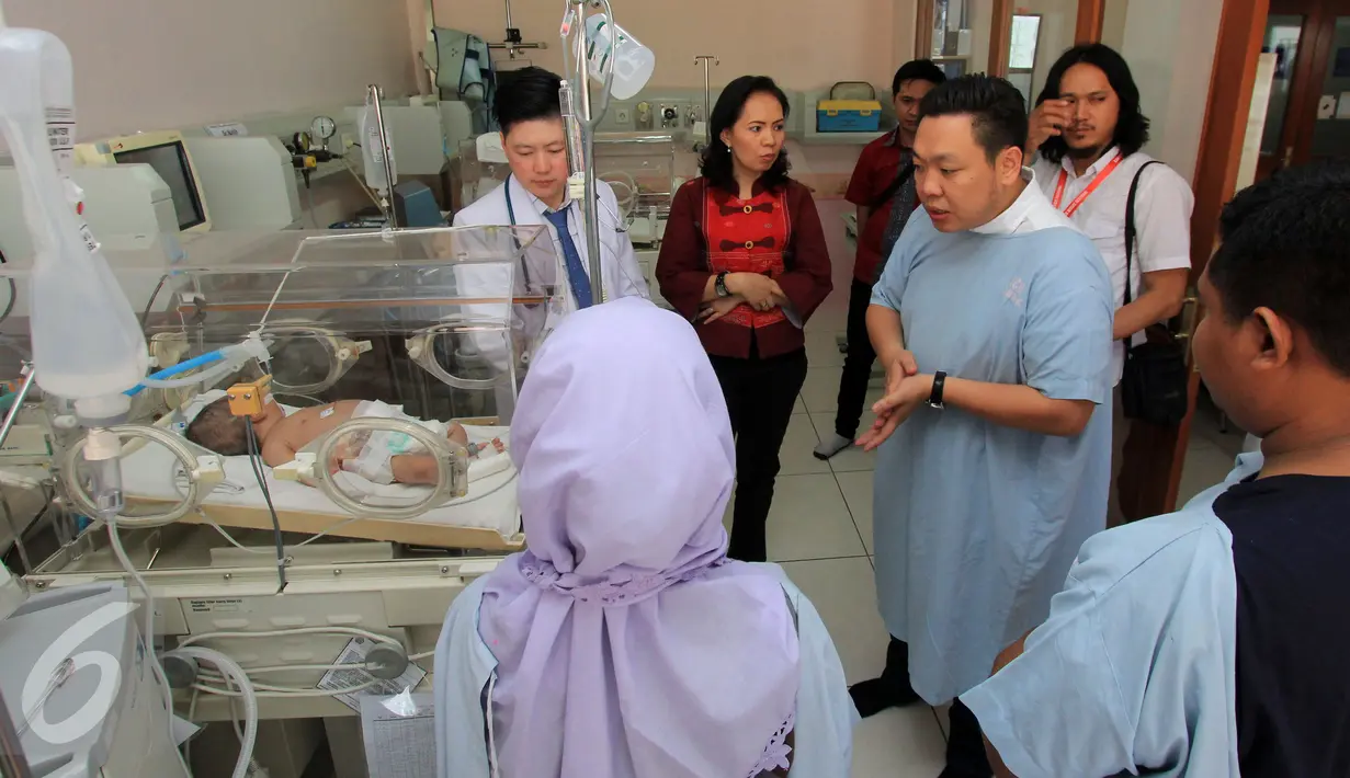 Anggota DPR RI Fraksi PDIP Charles Honoris (kiri)mewakili Wakil Gubernur DKI Jakarta Djarot saat menjenguk Bayi malang berumur satu bulan mengalami usus bocor di RS Husada, Jakarta Barat, Sabtu (11/6). (Liputan6.com/Johan Tallo)