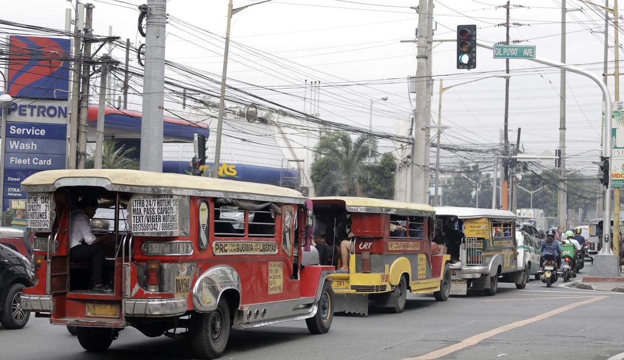 Deretan mobil Jeepney terjebak di antara kemacetan yang terjadi di Manila, Filipina, Jumat (22/11). Jeepney merupakan transportasi umum paling populer dan sudah menjadi ikon di Filipina. (Bola.com/M Iqbal Ichsan)