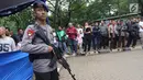 Polisi bersenjata melakukan penjagaan saat kegiatan penukaran uang pecahan di Lapangan IRTI Monas, Jakarta, Rabu (23/5). Penukaran uang pecahan kecil di IRTI Monas dilakukan dari 21-25 Mei sejak pukul 08.00-14.00 WIB. (Liputan6.com/Arya Manggala)