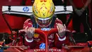 Pembalap Ferrari, Lewis Hamilton masuk ke kokpit mobilnya dalam sesi latihan bebas Formula 1 GP Australia 2025 di Sirkuit Albert Park, Melbourne, Australia pada Jumat (14/03/2025). (AFP/Saeed Khan)