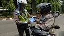 Polisi lalu lintas melakukan tilang terhadap pengendara motor saat razia Operasi Patuh Jaya 2019 di kawasan Kebon Nanas, Jakarta, Kamis (29/8/2019). Operasi ini diharapkan dapat meningkatkan kepatuhan dan ketertiban dalam berlalu lintas serta mengurangi angka kecelakaan. (merdeka.com/Imam Buhori)