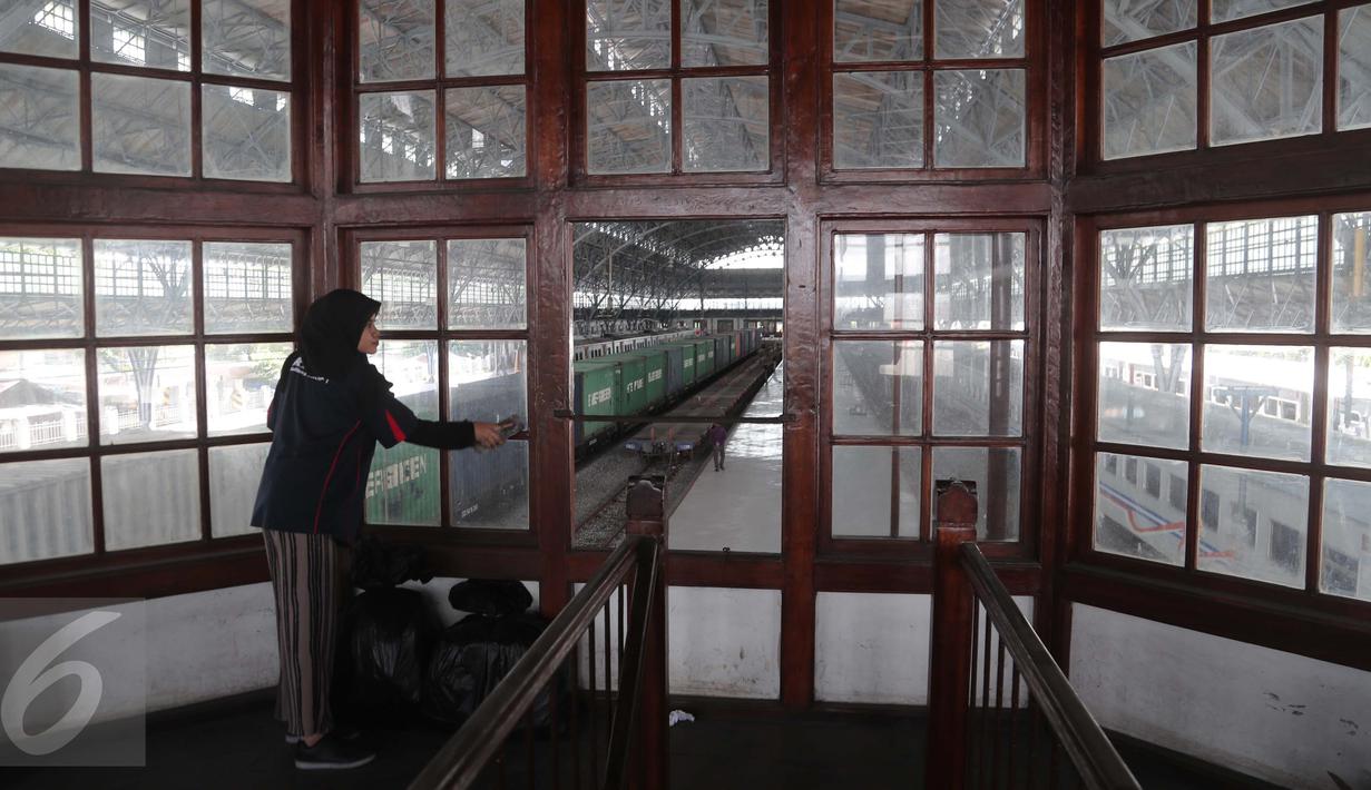 Seorang wanita dari komunitas Pecinta Kereta Api RD One membersihkan kaca jendela gedung di Stasiun Tanjung Priok, Jakarta Utara, Kamis (6/4). (Liputan6.com/Gempur M. Surya)