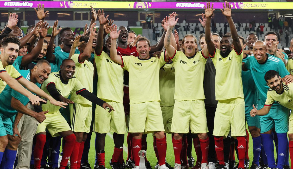 Sejumlah pesepak bola legendaris foto bersama staf FIFA pada laga hiburan jelang semi final Piala Dunia di Stadion Al Thumama, Senin (12/12/2022). (AFP/Karim Jaafar)