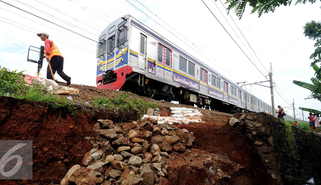 Pekerja meletakkan batuan untuk memperkuat struktur tanah yang longsor dekat rel KRL di sekitar Kampung Pabuaran, Bogor, Rabu (25/11/2015). Sebelumnya, Selasa (24/11) tanah di sekitar rel KM 38 dan 39 mengalami longsor. (Liputan6.com/Helmi Fithriansyah)