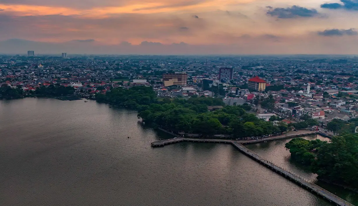 Foto udara memperlihatkan area Situ Cipondoh di Kota Tangerang, Banten, yang tetap berfungsi sebagai kawasan konservasi air sekaligus destinasi rekreasi warga, Rabu (14/4/2026). Berlokasi di Jalan KH Hasyim Ashari, Situ Cipondoh dibangun pada sekitar 1930-an pada masa pemerintahan kolonial Belanda sebagai danau buatan dengan fungsi utama mendukung kebutuhan masyarakat. (merdeka.com/Arie Basuki)