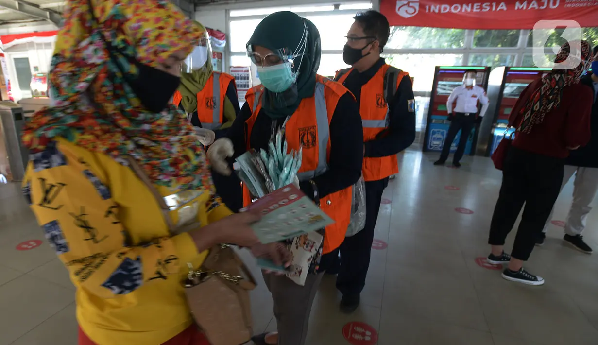 Petugas gabungan membagikan masker kepada calon penumpang  KRL jurusan Jakarta- Bogor di stasiun Tebet, Jakarta, Kamis (27/8/2020). Kegiatan tersebut merupakan rangkaian dari kampanye menggunakan masker di era Adaptasi Kebiasaan Baru untuk menghindari penularan COVID-19. (merdeka.com/Imam Buhori)