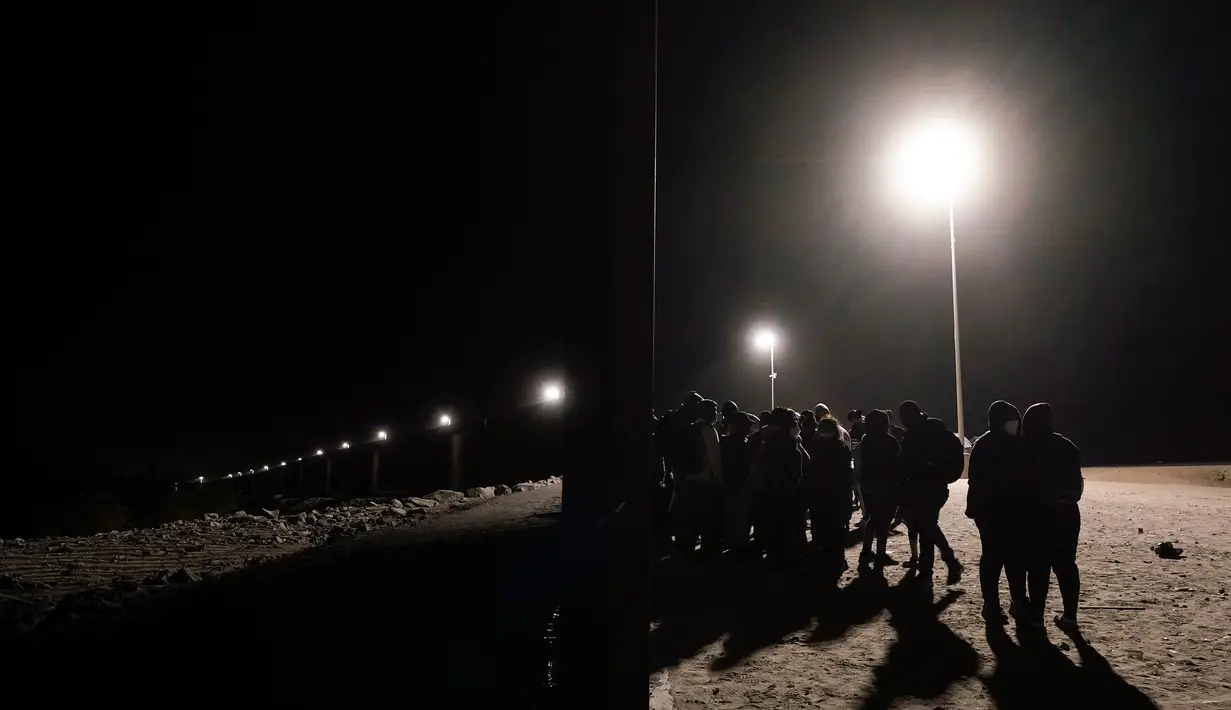 Orang-orang menunggu di sepanjang tembok perbatasan sebelum menyerah kepada pihak berwenang untuk mengajukan suaka di dekat Yuma, Arizona, Amerika Serikat, 3 November 2022. Meski tercatat rekor masuknya imigran di perbatasan Amerika Serikat-Meksiko dan kekurangan pekerja di Amerika Serikat, para ahli percaya kebijakan imigrasi Amerika Serikat akan tidak berubah setelah pemilu paruh waktu nanti. (AP Photo/Gregory Bull)