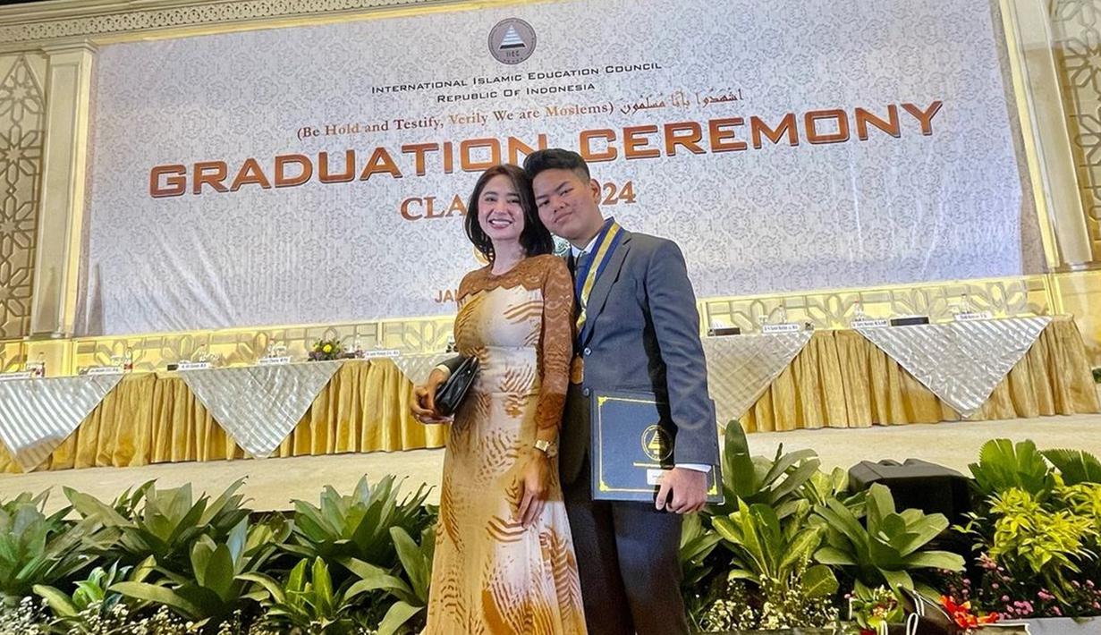 Dewi Perssik membagikan momen bahagianya bisa hadir di wisuda kelulusan SMA sang anak angkat. Diketahui, Gegep bersekolah di International Islamic Education Council. Pedangdut yang akrab disapa Depe itu pun mengungkapkan rasa syukur, bahagia sekaligus bangga terhadap sang putra. (Liputan6.com/IG/@dewiperssik9)