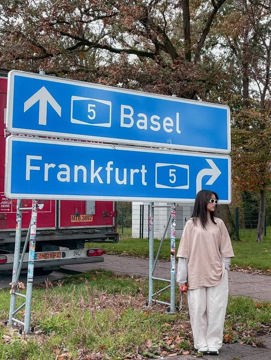 Gaya kasual Fuji memadukan atasan kaus lengan panjang abu-abu dengan oversized tee berwarna cokelat yang serasi dengan celana panjangnya yang bernuansa putih gading. [Foto: Instagram/fuji_an]