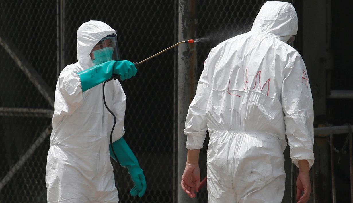 Seorang petugas kesehatan menerima desinfeksi setelah pemusnahan unggas di sebuah pasar di Hong Kong, (7/6). Pihak berwenang akan mengadakan pertemuan untuk mengevaluasi risiko dan memutuskan berapa lama penangguhan akan dilaksanakan. (REUTERS/Bobby Yip)