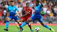 Gelandang Liverpool, Georginio Wijnaldum berusaha melewati dua pemain Arsenal, Alex Oxlade-Chamberlain dan Danny Welbeck pada Liga Inggris di Anfield, Liverpool, Inggris (27/8). Liverpool menang atas Arsenal dengan skor 4-0. (Peter Byrne/PA via AP)