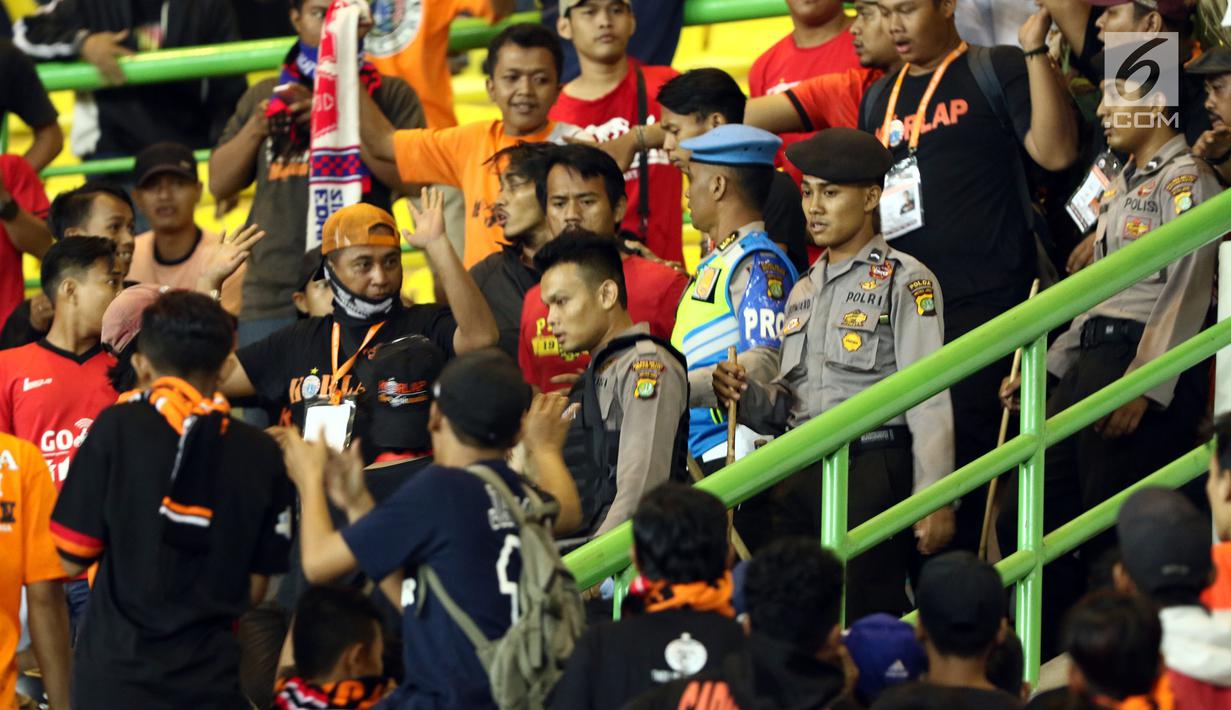 Polisi menertibkan ulah suporter Persija yang menyaksikan laga tim Macan Kemayoran lawan Perserui dilanjutan Liga 1 Indonesia di Stadion Patriot Candrabhaga, Bekasi, Selasa (13/6). Persija menang telak 3-0 atas perserui. (Liputan6.com/Helmi Fithriansyah)