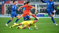 Aksi bintang Timnas China, Wu Lei (merah) saat menghadapi hadangan dari kiper Timnas Singapura, Hassan Sunny di putaran kedua Kualifikasi Piala Dunia 2026. (AFP).