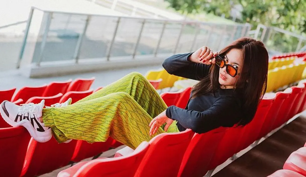 Mengenakan kaus gelap dan kacamata hitam, Mahalini tampil dengan gaya yang terkesan girl boss style. Ditambah lagi dengan celana hijau yang menambah warna cerah di OOTD-nya. (Liputan6.com/IG/@mahaliniraharja)