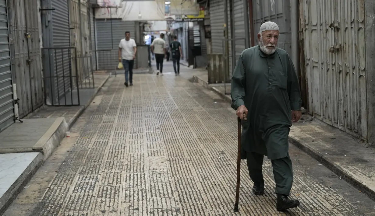 Seorang pria Palestina berjalan melalui kota Nablus di Tepi Barat, di mana toko-toko tutup sebagai bagian dari pemogokan umum menyusul pembunuhan pemimpin Hamas Ismail Haniyeh, Rabu (31/7/2024). (AP Photo/Majdi Mohammed)