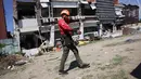 Seorang penyelamat berjalan melewati bangunan yang rusak akibat gempa bumi di General Santos, Filipina, Selasa 9 Juni 2026. (AP Photo/Basilio Sepe)