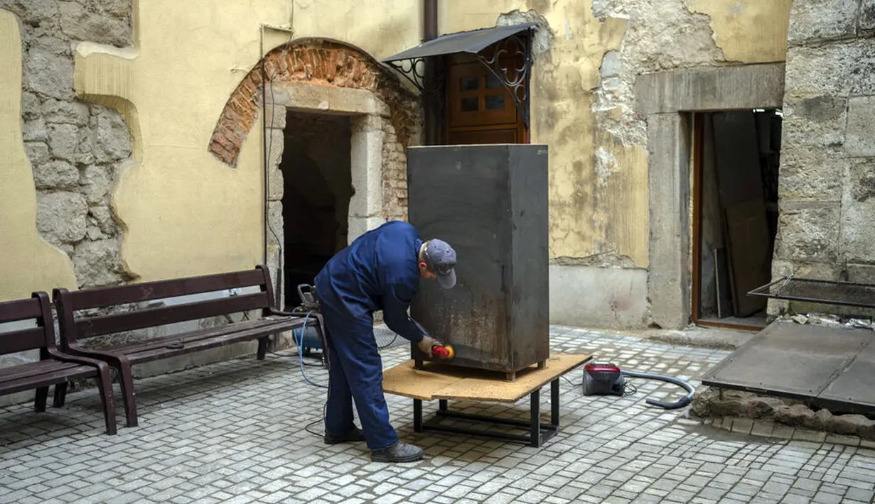 Seorang pekerja Museum Sejarah Agama membangun sebuah kotak untuk melindungi artefak jika terjadi serangan Rusia di Kota Lviv, Ukraina, 4 Maret 2022. (AP Photo/Bernat Armangue)
