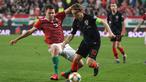 Aksi Luka Modrid melewati pemain Hungaria, Adam Szalai pada laga kedua babak kualifikasi Piala Eropa 2020 Grup E yang berlangsung di Stadion Groupama Arena, Budapest, Senin (25/3). Kroasia kalah 1-2 kontra Hungaria. (AFP/Attila Kisbenedek)