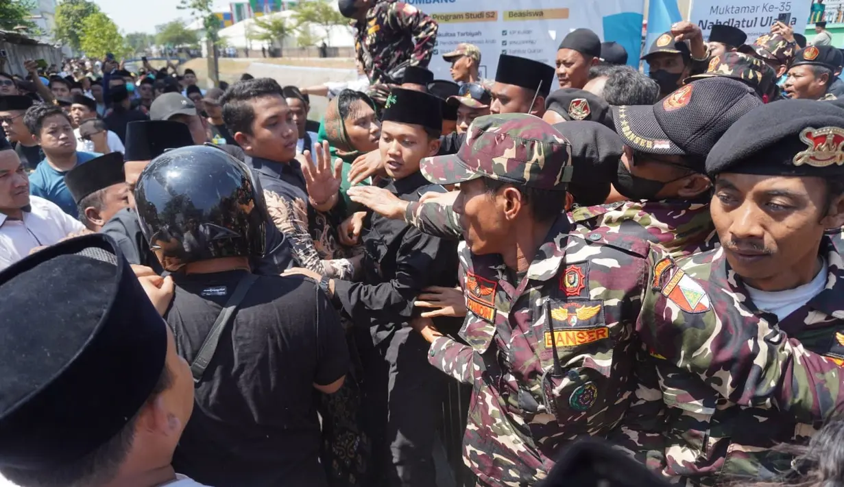 Aksi saling dorong terjadi antara orang--orang yang memprotes aturan iddah politik selama setahun bagi ketum PBNU dengan banser yang berjaga di halaman depan ruang sidang Pleno Muktamar ke-35 NU. (Liputan6.com/ Ahmad Apriyono)
