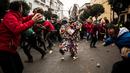 Orang-orang melempari seorang pria berkostum ala setan dengan sayuran lobak selama Festival Jarramplas di kota Piornal, Spanyol, Sabtu (19/1). Sembari dilempari lobak, sang Jarramplas tetap berjalan dan terus memukul drum yang dibawanya. (AP/Javier Fergo)