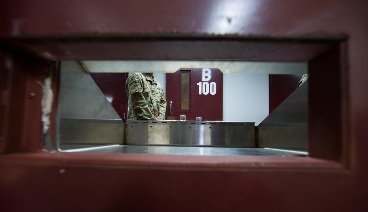 Seorang tentara AS berdiri dekat pintu sel dalam penjara Camp VI Pangkalan Angkatan Laut Teluk Guantanamo, Kuba, Rabu 17 April 2019. Penjara Guantanamo merupakan penjara paling aman dengan sekuriti yang berlapis-lapis. (AP Photo/Alex Brandon)