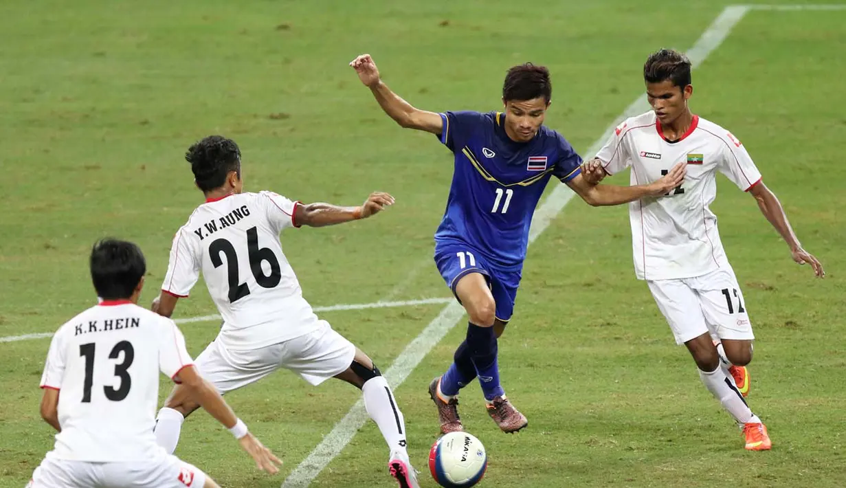 Pemain Thailand U-23 berebut bola dengan pemain Myanmar U-23 dalam final sepak bola SEA Games 2015. (Bola.com/Arief Bagus)