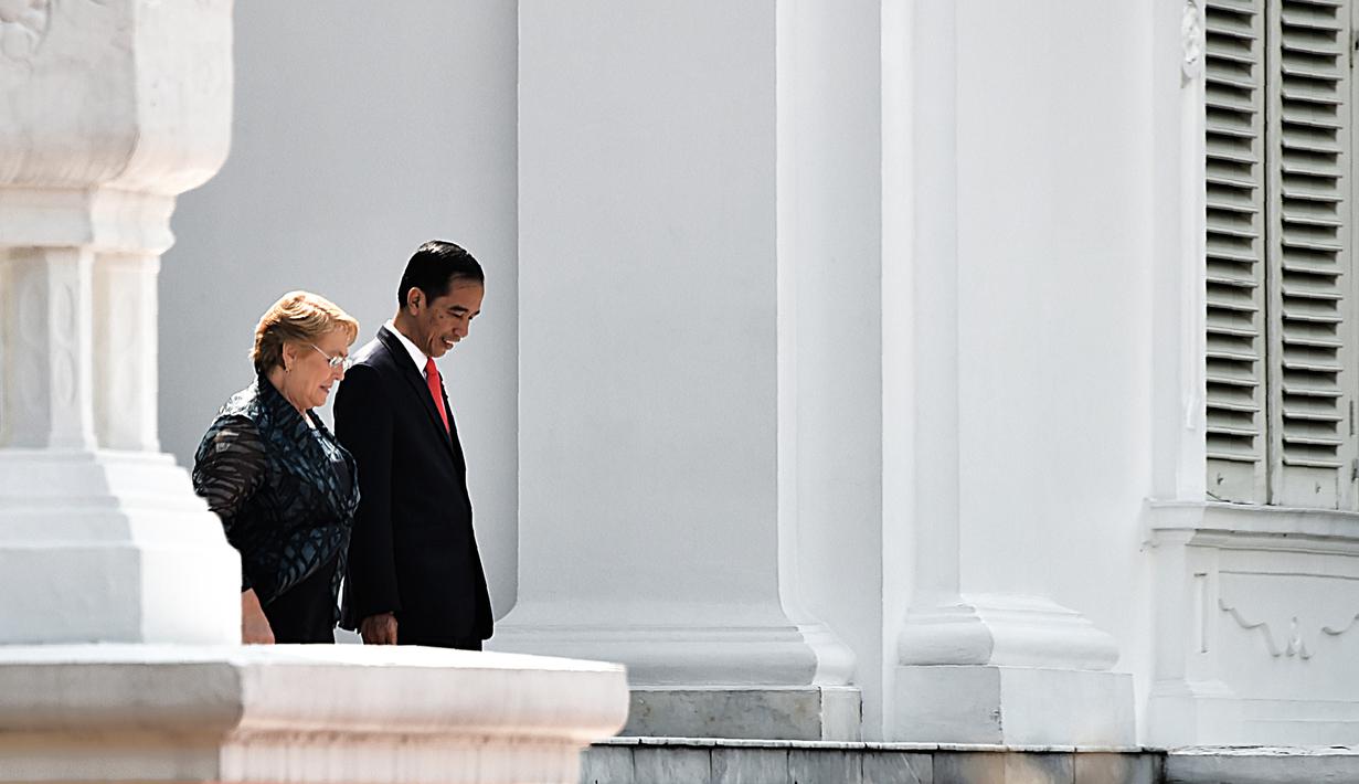 Presiden Joko Widodo (Jokowi) dan Presiden Republik Chile, Michelle Bachelet  berjalan menuju Istana Merdeka, Jakarta, Jumat (12/5). Kedua negara akan mengadakan perbincangan bilateral dan menjadi saksi penandatanganan MoU kedua negara. (Bay ISMOYO/AFP)