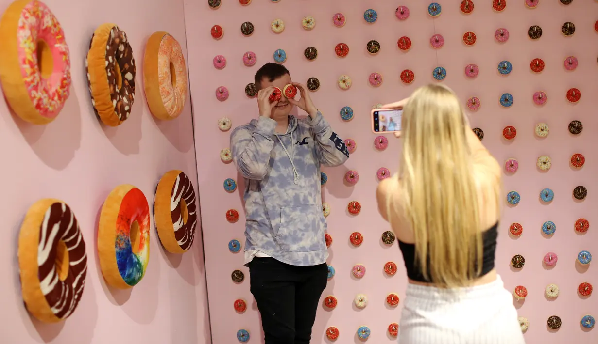 Pengunjung berfoto ketika mengunjungi The Selfie Factory di pusat perbelanjaan Westfield, London pada 11 September 2019. Tersedia 20 booth tematik, dengan latar belakang unik dan berbeda, dari dinding donat hingga restoran bergaya 1950-an. (Isabel INFANTES / AFP)