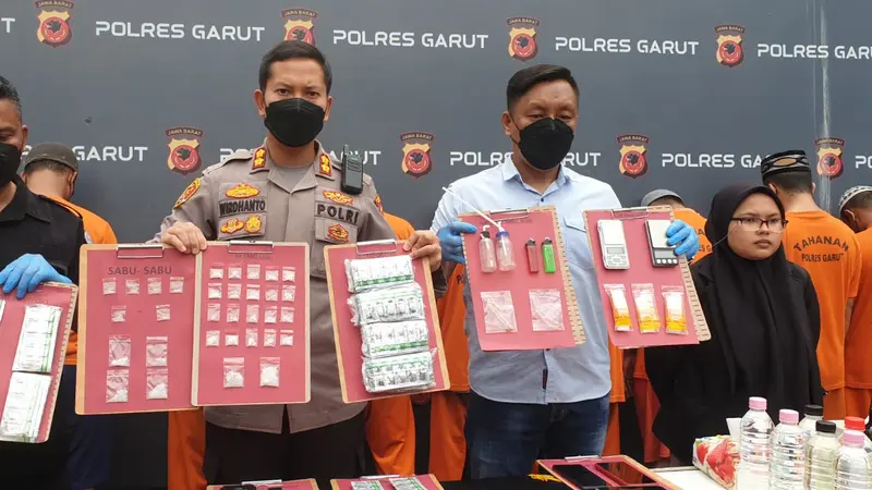 Kapolres Garut AKBP Wirdhanto Hadicaksono, didampingi Kasat Narkotika menunjukan barang bukti penyalahgunaan obat terlarang, dalam rilis kasus di Mapolres Garut, Kamis (15/12/2022). (Liputan6.com/Jayadi Supriadin)