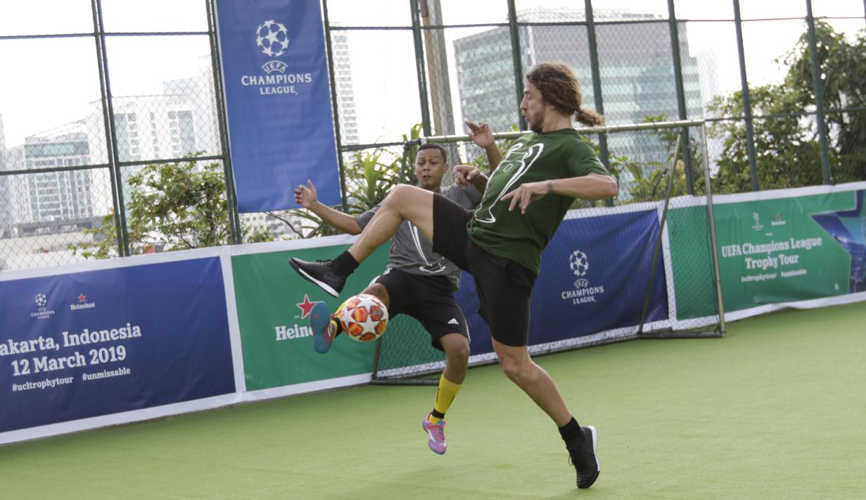 Legenda Barcelona, Carles Puyol, berebut bola saat bermain futsal di Lapangan Menara Imperium, Jakarta, Selasa (12/3). Pertandingan tersebut merupakan bagian dari kegiatan UEFA Champions League Trophy Tour di Jakarta. (Bola.com/M Iqbal Ichsan)
