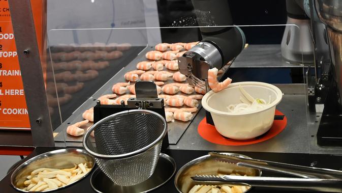 Robot koki bernama Sophie meracik semangkuk laksa saat demonstrasi memasak di Singapura pada 26 Juli 2019. Selain itu robot koki tersebut juga dirancang bisa membersihkan meja dapurnya secara otomatis. (Roslan RAHMAN / AFP)