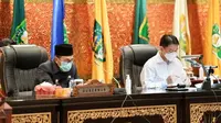 Gubernur Riau Syamsuar (kiri) sebelum terkonfirmasi Covid-19 saat mengikuti sidang paripurna di DPRD. (Liputan6.com/M Syukur)