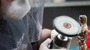 Seorang pekerja yang bernama Leo Sotelo menyelesaikan pembuatan Piala Oscar di tempat produksi Polich Tallix Fine Art Foundry, New York, AS (13/1). Piala tersebut menggambarkan seorang kesatria dengan 5 jari-jari. (AFP/Don Emmert)