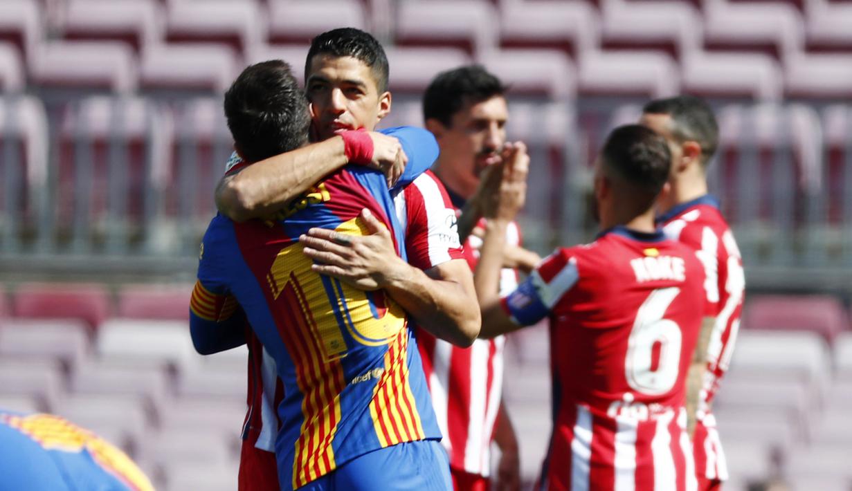 Striker Atletico Madrid, Luis Suarez, berpelukan dengan striker Barcelona, Lionel Messi, pada laga Liga Spanyol di Stadion Camp Nou, Sabtu (8/5/2021). Kedua tim bermain imbang 0-0. (APJoan Monfort)