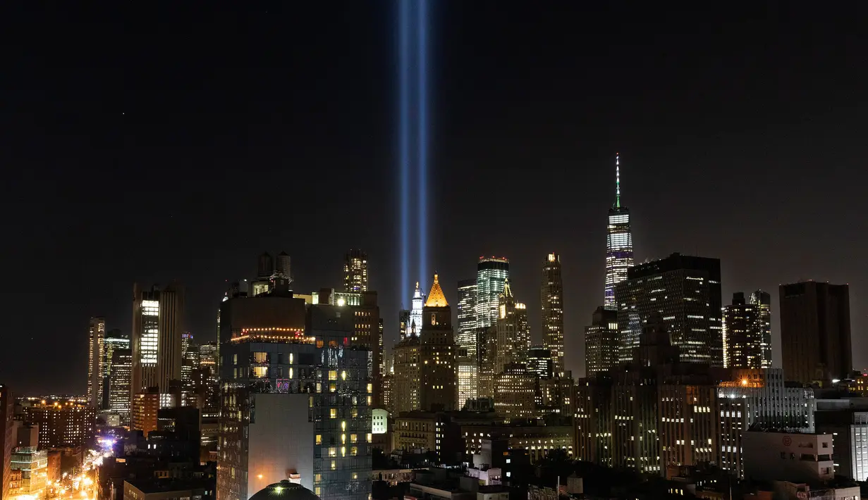 Instalasi cahaya bertajuk 'Tribute in Light' menerangi langit di lower Manhattan, New York, Selasa (10/9/2019). Cahaya kembar berwarna biru tersebut dinyalakan untuk memperingati 18 tahun peristiwa serangan gedung kembar World Trade Center (WTC) pada 11 September 2001 silam. (AP/Mark Lennihan)