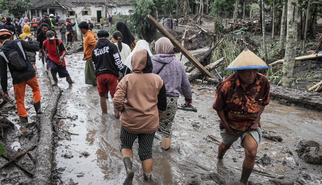 Tercatat, ada dua desa yang mengalami kerusakan parah, menjadi gelap gulita akibat abu vulkanik tebal, dan sebagian wilayahnya luluh lantak diterjang awan panas, yakni Desa Supiturang dan Dusun Kamar Kajang di Lumajang, Jawa Timur. Tampak dalam foto, orang-orang berjalan di tanah yang tertutup abu vulkanik setelah aliran piroklastik selama letusan Gunung Semeru di Desa Supiturang, Lumajang, Jawa Timur pada Kamis 20 November 2025. (Agus Harianto/AFP)