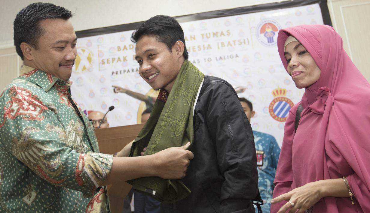 Pesepak bola Indonesia, Evan Dimas, menerima sarung dari Menpora, Imam Nahrawi. Sarung ini diberikan Menpora agar Evan tetap rajin menunaikan ibadah salat. (Bola.com/Vitalis Yogi Trisna)