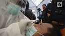 Petugas medis melakukan rapid test pada pengendara yang terjaring razia masker di Jalan Panjang, Kedoya, Jakarta Barat, Senin (2812/2020). Pengendara yang tidak mengenakan masker langsung menjalani rapid test antigen gratis untuk mencegah penularan COVID-19. (merdeka.com/Dwi Narwoko)