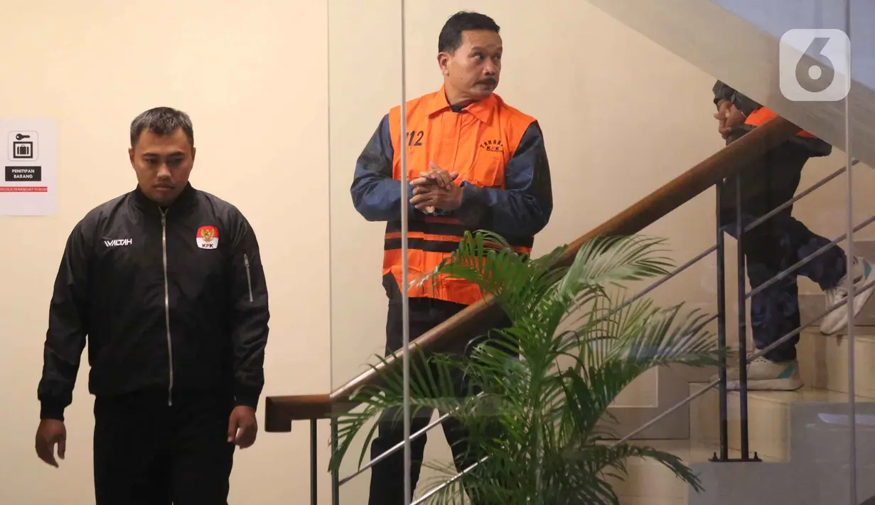 Selain itu, Maidi juga diduga melakukan tindak pidana korupsi berupa permintaan fee penerbitan perizinan di lingkungan Pemkot Madiun kepada pelaku usaha seperti hotel, minimarket, hingga waralaba. Tampak dalam foto, Wali Kota Madiun, Maidi (kanan) dijaga petugas saat menuju mobil tahanan usai pemeriksaan intensif di Gedung Merah Putih Komisi Pemberantasan Korupsi (KPK0, Jakarta, Selasa (20/1/2026). (Liputan6.com/Helmi Fithriansyah)