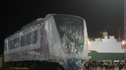 Pekerja dibantu alat berat menarik gerbong kereta ringan/Light Rail Transit (LRT) di Pelabuhan Car Terminal, Tanjung Priok, Jakarta, Jumat (13/4). Gerbong ini akan langsung diangkut menuju Dipo LRt di Kelapa Gading.  (Merdeka.com/Imam Buhori)